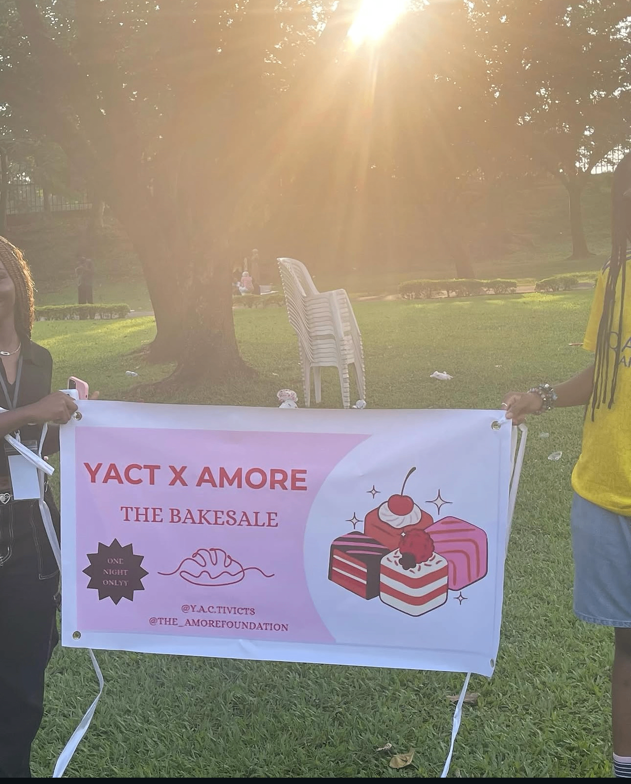 Volunteers holding the YACT x Amore bake sale banner