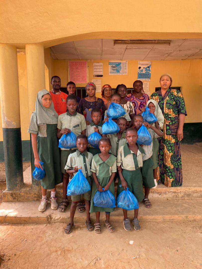 Students at a partner school holding food parcels from YACT